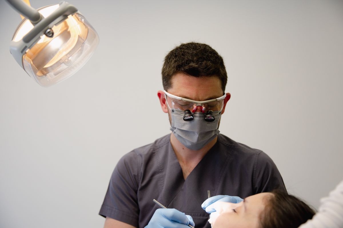 A dentist reviewing a patient at a follow-up visit