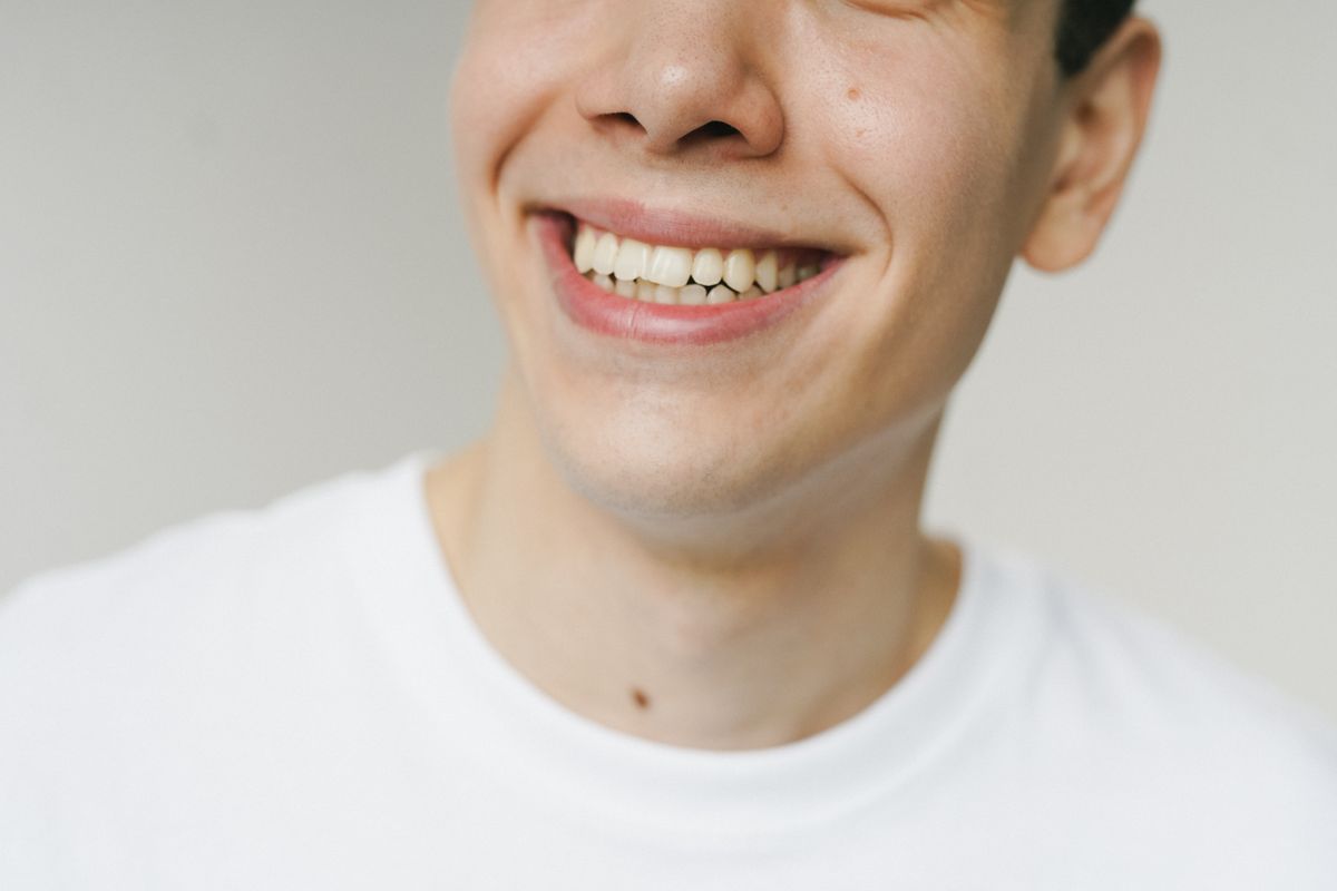 A person smiling naturally against a light background